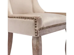 Conjunto de 2 sillas de terciopelo beige con patas de madera curvadas y remaches dorados.