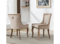 Conjunto de 2 sillas de terciopelo beige con patas de madera curvadas y remaches dorados.