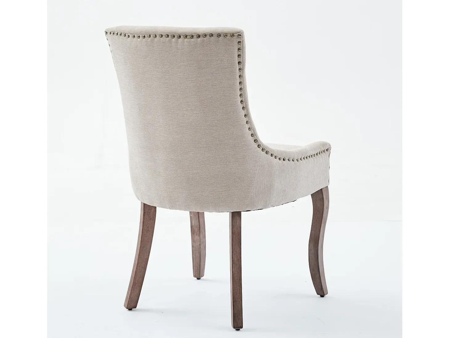 Juego de 2 sillas beige con patas de madera curvadas y ribete de tachuelas.