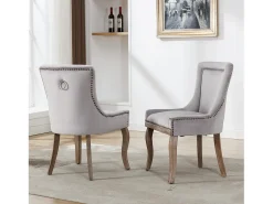 Juego de 2 sillas de terciopelo gris con patas de madera curvadas y remaches dorados.