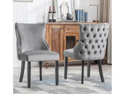 Juego de 2 sillas de terciopelo gris con patas de madera gris, botones decorativos y remaches plateados.